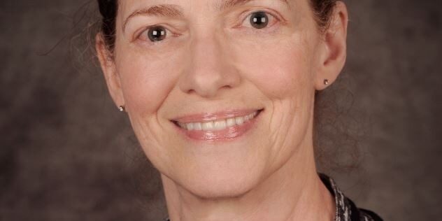 A woman with brown hair and wearing a necklace.