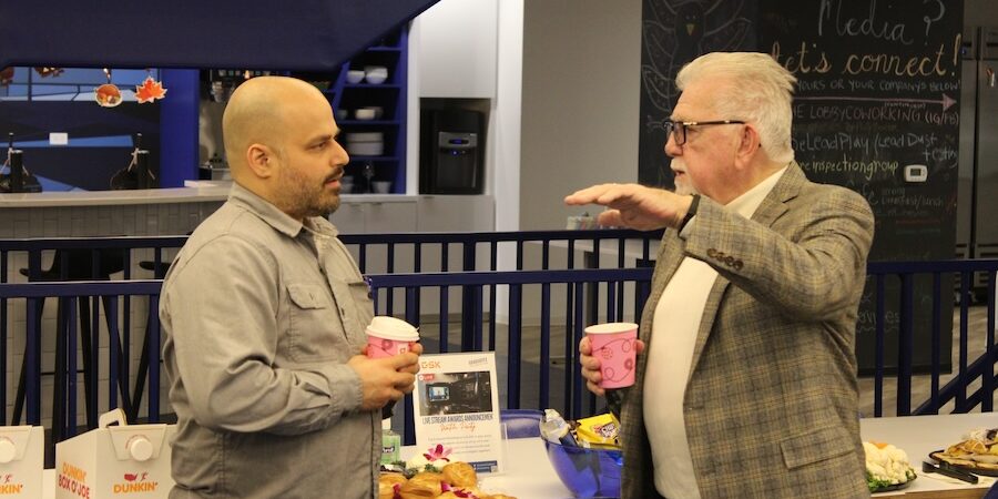 Two men are talking to each other at a table.