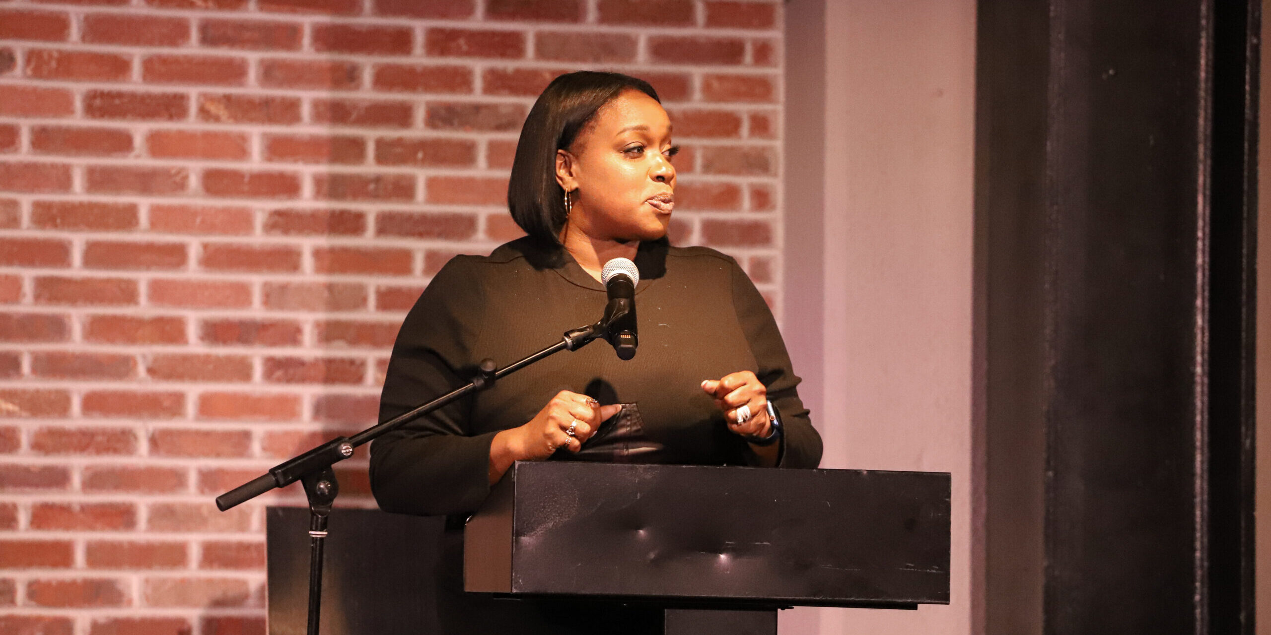 A woman standing at a podium with a microphone.
