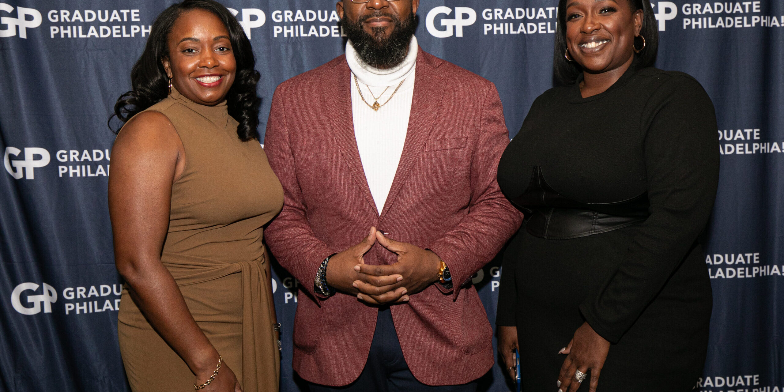 Three people posing for a picture at the graduate philadelphia awards.