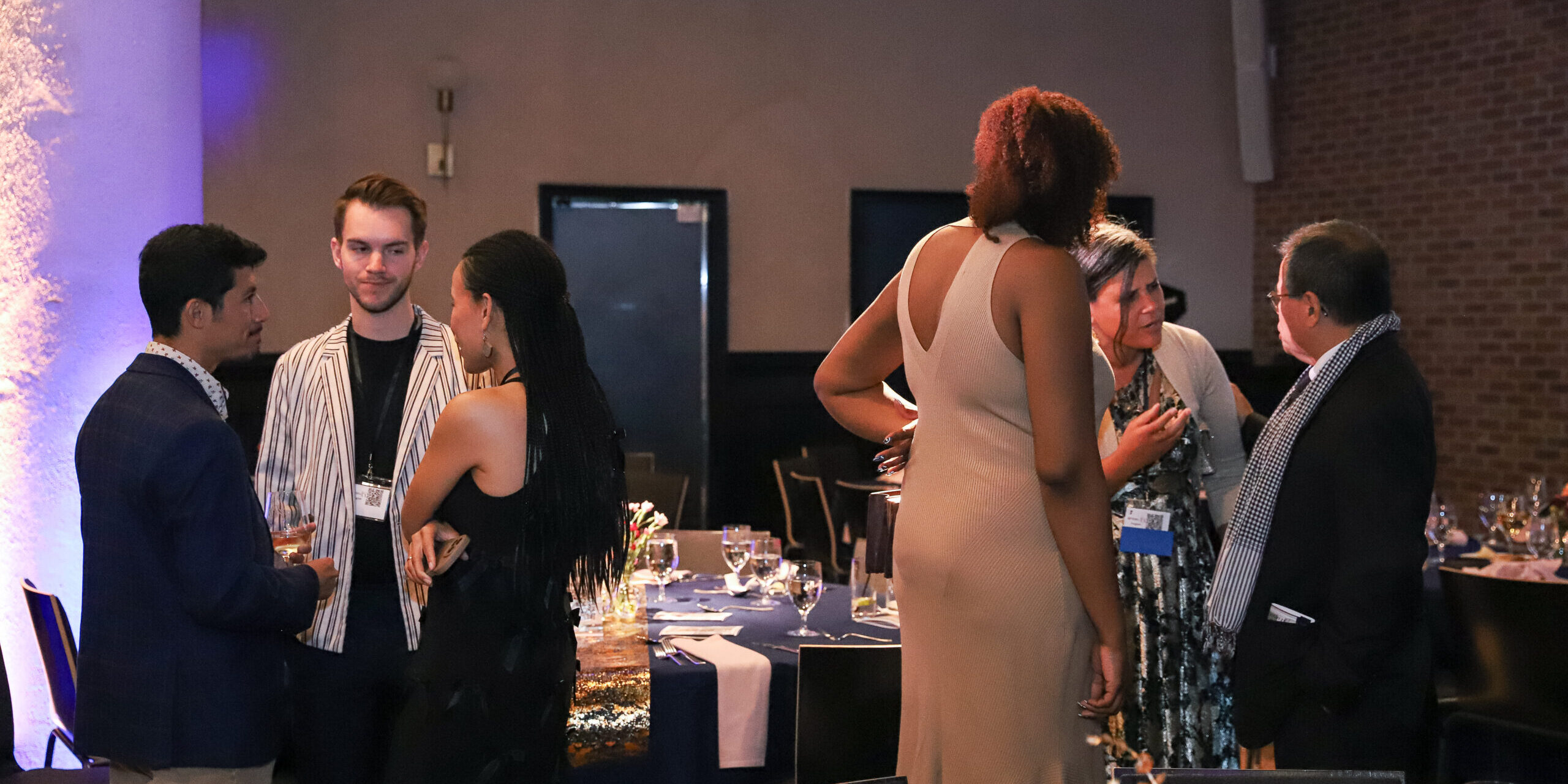 A group of people standing around a room.