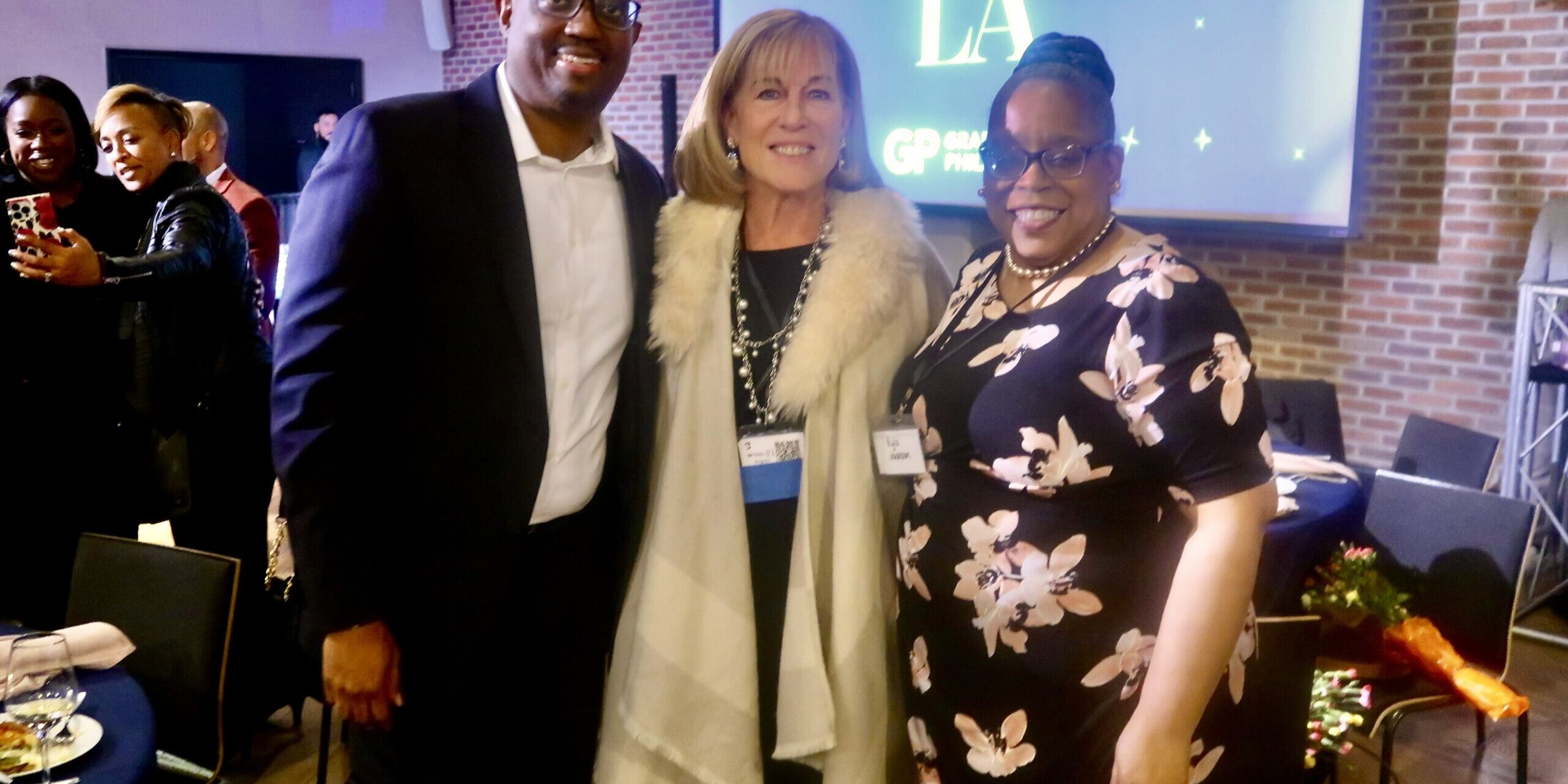 Three people posing for a picture at an event.