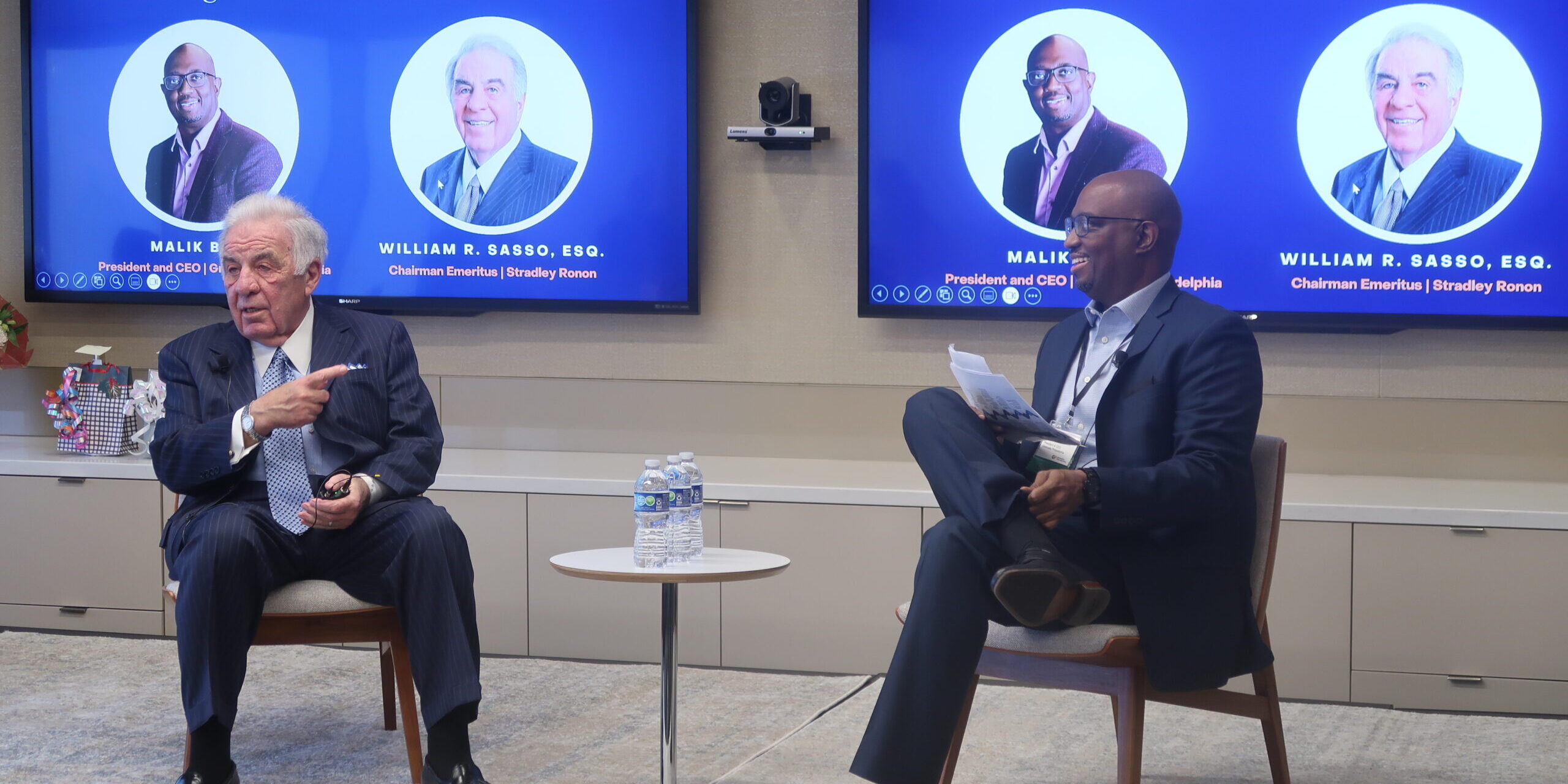 Two men sitting in front of a tv.