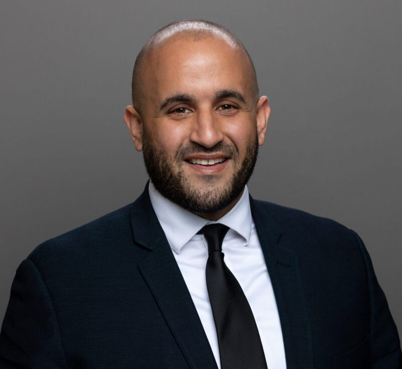 A man in a suit and tie smiling for the camera.