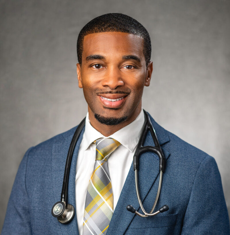 A man in a suit and tie with a stethoscope around his neck.